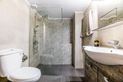 a bathroom with a toilet and a sink and a shower at CENTRO PATRAS in Patra