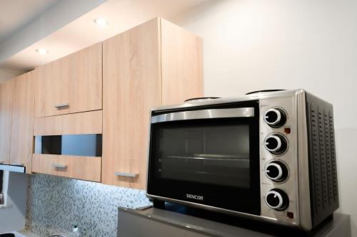 a microwave oven sitting next to wooden cabinets at CENTRO PATRAS in Patra