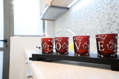 four red coffee mugs sitting on a shelf at CENTRO PATRAS in Patra