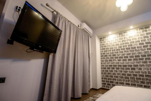 a flat screen tv hanging on a wall in a bedroom at CENTRO PATRAS in Patra