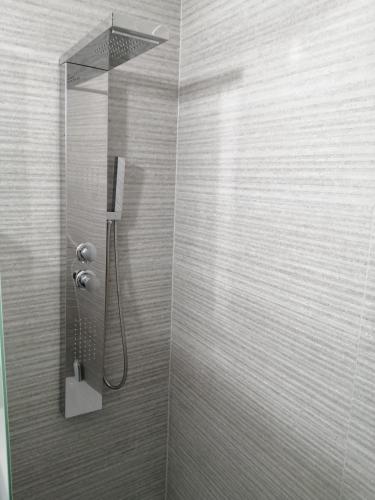 a bathroom with a shower with a shower head at Contact Hôtel Arc-En-Ciel - Réouverture - Rénové in Mulhouse