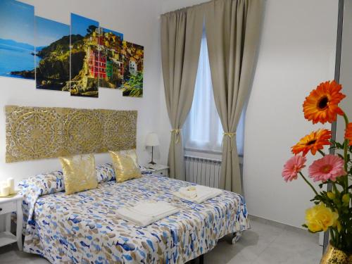 - une chambre avec un lit et un vase avec des fleurs dans l'établissement Valentyna Rooms, à La Spezia