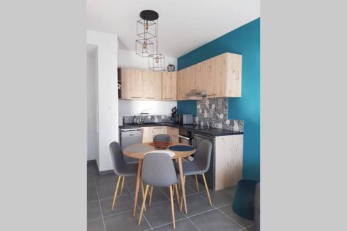 uma pequena cozinha com mesa e cadeiras em Appartement le Michel ange em Briançon