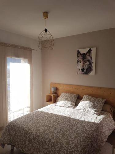 - une chambre dotée d'un lit avec une photo de loup sur le mur dans l'établissement Appartement le Michel ange, à Briançon