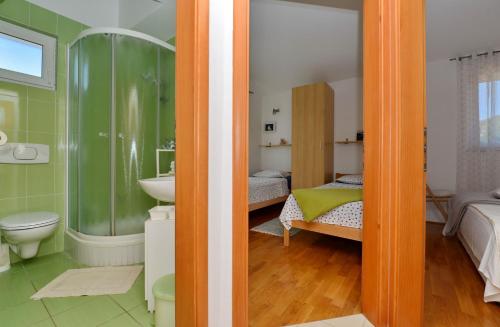 a bathroom with a sink and a toilet and a bedroom at Apartmani Vila Karla, Dobropoljana, otok Pašman in Dobropoljana