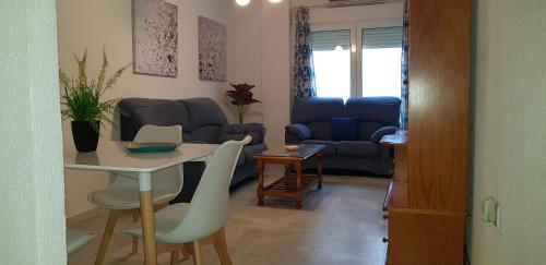 sala de estar con mesa y sofá en Apartamento Santa Barbara, en Conil de la Frontera