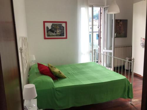 Cama verde en habitación blanca con manta verde en Salto del Gatto, en La Spezia