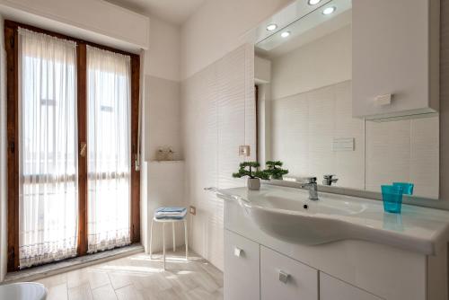 een witte badkamer met een wastafel en een spiegel bij Pepita del mare in Alghero