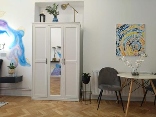 een witte deur in een kamer met een tafel en een stoel bij Lionas Central Apartment in Bistriţa