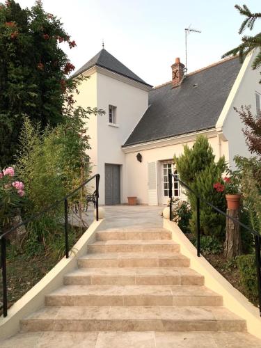 a stairway leading to a white house at La Tour de Saint Cyr in Saint-Cyr-sur-Loire