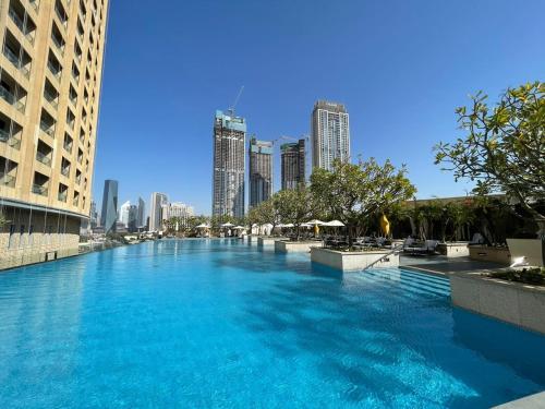 a large swimming pool in a city with tall buildings at Luxury residence at Dubai Mall in Dubai