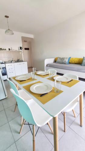 - une table à manger blanche avec des assiettes et des chaises dans l'établissement BellaVista Departamento Temporario, à Paraná