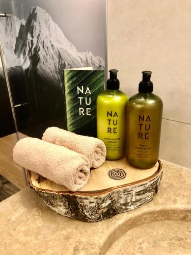 two bottles of shampoo and towels on a bathroom counter at moser-HOCHKÖNIG Genuss Wirtshaus Hotel in Maria Alm am Steinernen Meer
