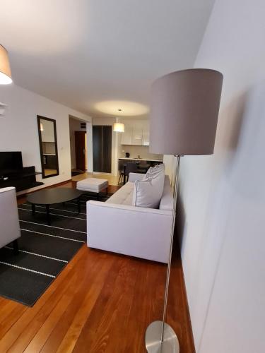 a living room with a white couch and a lamp at Apartman Ibarstar in Vrnjačka Banja