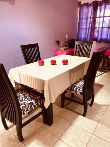 a dining room table with two chairs and a white table cloth at El paraíso de Zacatlán, Departamento con Terraza, 10 pax in Zacatlán
