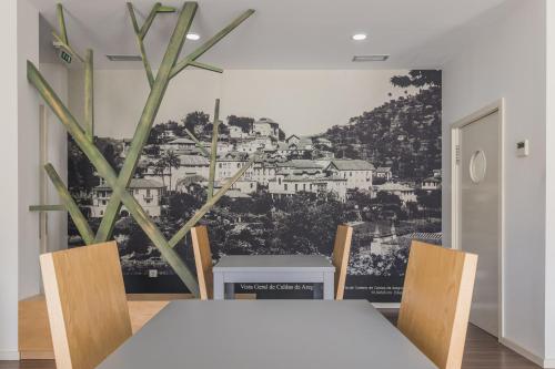 uma sala de jantar com uma mesa e cadeiras brancas em Hotel Comércio em Resende