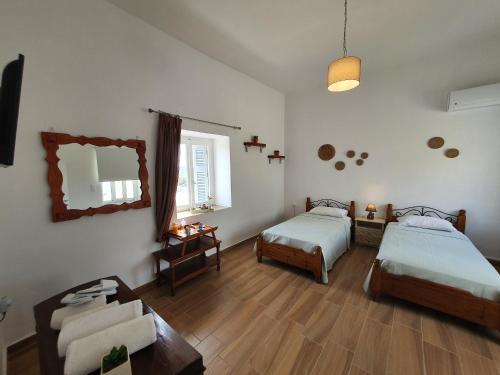 Cette chambre comprend deux lits, un canapé et un miroir. dans l'établissement Vira Señor House, à Triovasálos