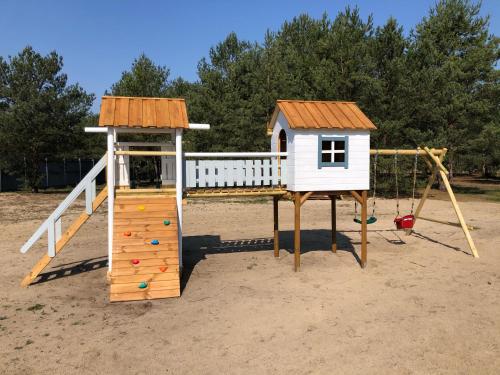 plac zabaw z domem i zjeżdżalnią w obiekcie Kwiejcówka w mieście Kwiejce