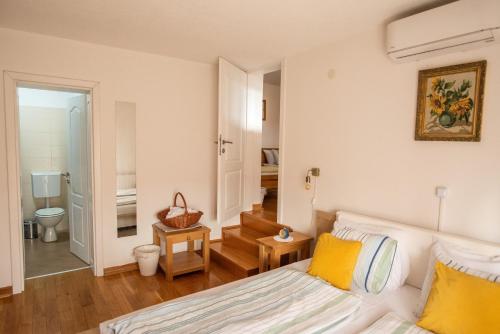 a bedroom with a bed with yellow pillows at Kuća za odmor Vallirea in Kaptol