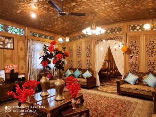 a living room with a couch and a table with flowers at The Heritage Gemini Group of Houseboat in Srinagar