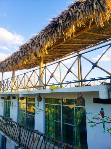 a building with a thatched roof and a balcony at La Casa de las Aves in Bacalar