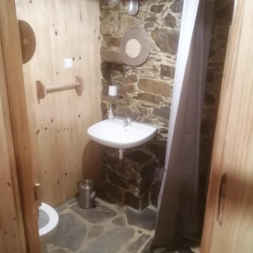 a stone bathroom with a sink and a toilet at Casa Branca in Lousã