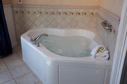 a bath tub filled with water in a bathroom at Edgewater Beach Resort, a VRI resort in Dennis Port