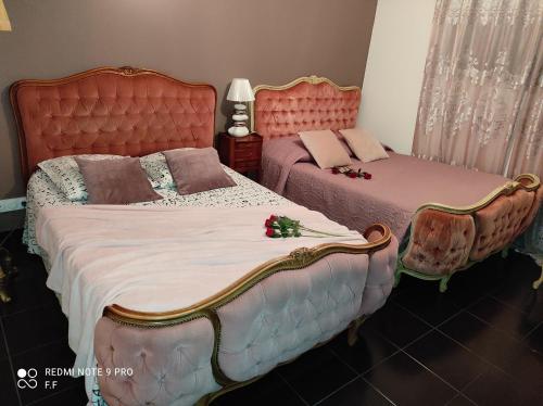 um quarto com 2 camas e cabeceiras vermelhas em La maison écolo de Nono em Dhuizon