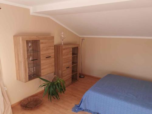 1 dormitorio con 1 cama azul y armario de madera en Apartment Lietzow/Rügen/Insel Rügen 2913, en Lietzow