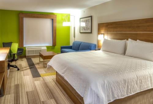 a hotel room with a bed and a desk and a chair at Holiday Inn Express Hotel and Suites Lincoln Airport, an IHG Hotel in Lincoln