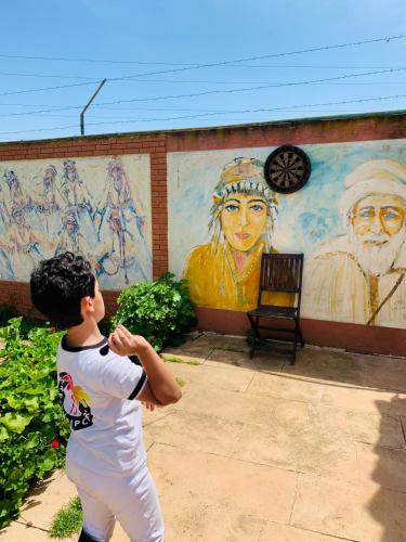 a young boy standing in front of a mural at Equi Palace & SPA Near Aeroport in Berrechid