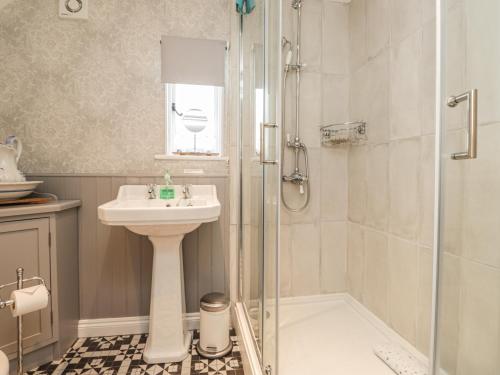 a bathroom with a sink and a shower at Rose Cottage in Deal