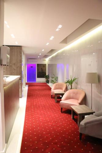 a lobby with pink chairs and a red carpet at مندرين للشقق المخدومة in Taif