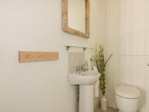 a bathroom with a sink and a toilet and a mirror at Offshore in Newquay