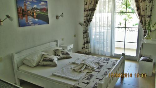 een wit bed in een kamer met een raam bij Zeybek 1 Pension in Patara