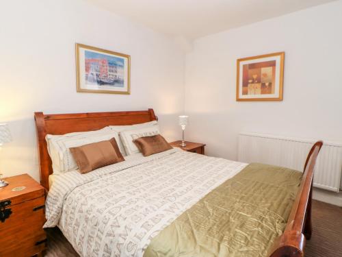 オールストンにあるKings Cottageのベッドルーム1室(大型ベッド1台、木製ヘッドボード付)