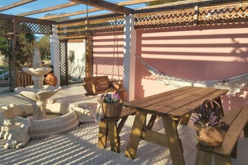 a patio with a wooden table and a hammock at Casa dos Malmequeres in Sintra