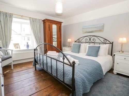 - une chambre avec un grand lit et une fenêtre dans l'établissement Shamrock Cottage, à Grange-over-Sands