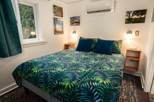 1 dormitorio con 1 cama con manta azul y verde en Secluded 2 Bdm Patio Villa Right By All The Action, en Portland