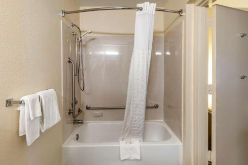 a bathroom with a shower with a white tub at Quality Inn Duluth - Atlanta Northeast in Duluth
