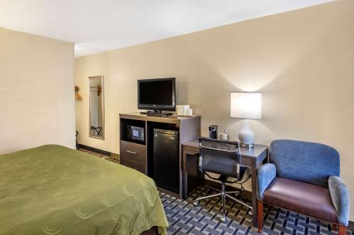 a hotel room with a bed and a desk with a television at Quality Inn Duluth - Atlanta Northeast in Duluth