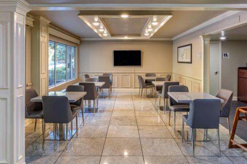 a waiting room with tables and chairs and a flat screen tv at Quality Inn Duluth - Atlanta Northeast in Duluth