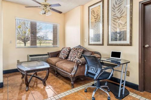 a living room with a couch and a desk with a laptop at Econo Lodge Inn & Suites Macon West in Macon