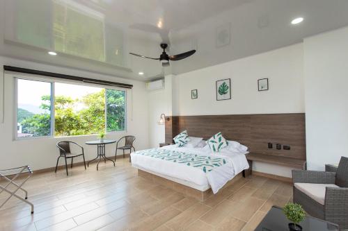 Schlafzimmer mit einem Bett, einem Tisch und Stühlen in der Unterkunft Hotel Natural Hill's by H&R in Villeta