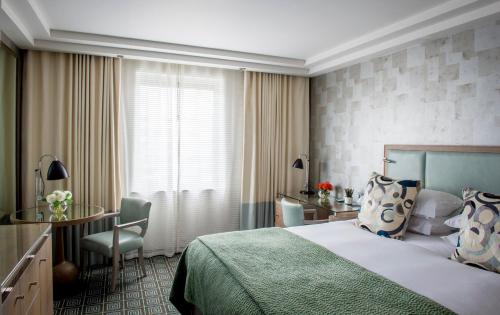 a hotel room with a bed and a desk and a table at The Marylebone Hotel in London