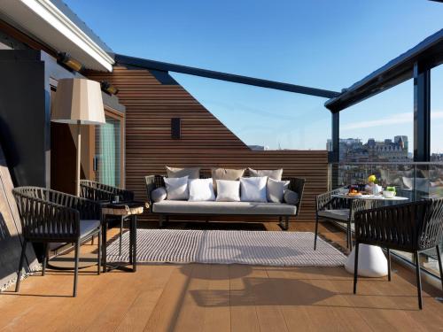 a patio with a couch and chairs on a balcony at The Marylebone Hotel in London