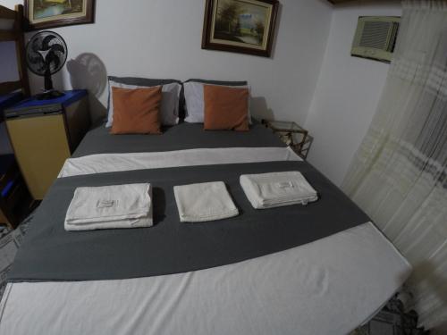 a bedroom with a bed with two towels on it at Casa Vila Mar - Inn Prainha in Arraial do Cabo