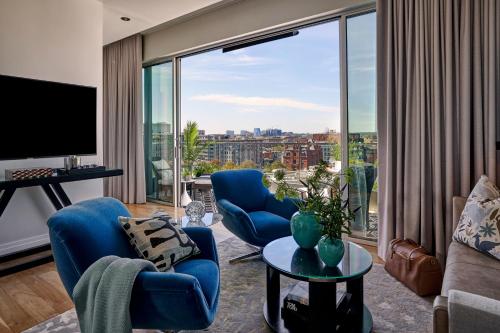 a living room with blue chairs and a large window at The Dupont Circle Hotel in Washington