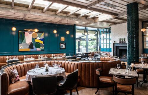 a restaurant with tables and chairs and a fireplace at The River Lee Hotel a member of The Doyle Collection in Cork