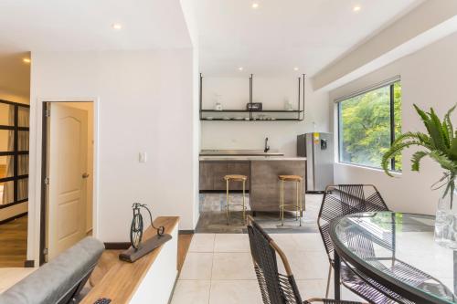a kitchen and living room with a glass table at Soy Local Primavera in Medellín